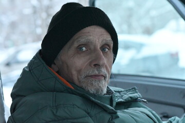 portrait of a man in winter clothes in a car
