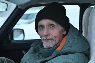 portrait of a man in winter clothes in a car