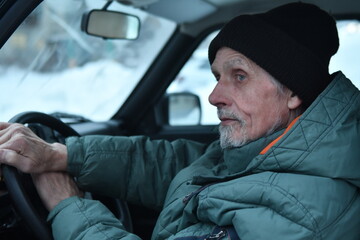 portrait of a man in winter clothes in a car