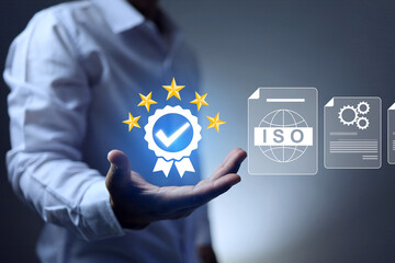 ISO standards certification concept with a businessman holding certified mark to qualified products quality standard requirement and passed audit according to industrial regulation