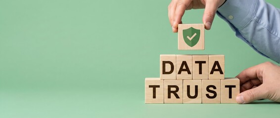 Man stacking wooden blocks with DATA TRUST and shield icon, building security and reliability Concept of data protection, cybersecurity, and integrity