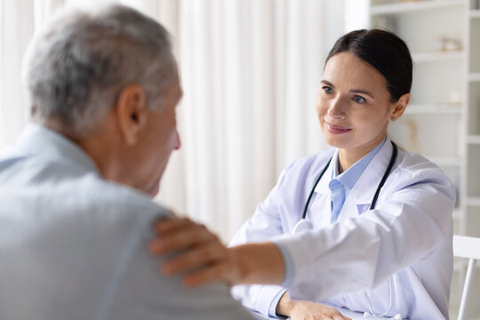 Female doctor offering emotional support to stressed senior male patient during consultation, compassionate healthcare and mental support concept