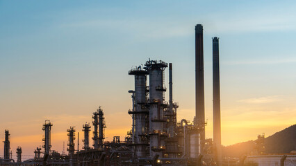distillation tower at sunset. fluid catalytic cracking distillation unit of oil refinery industrial...