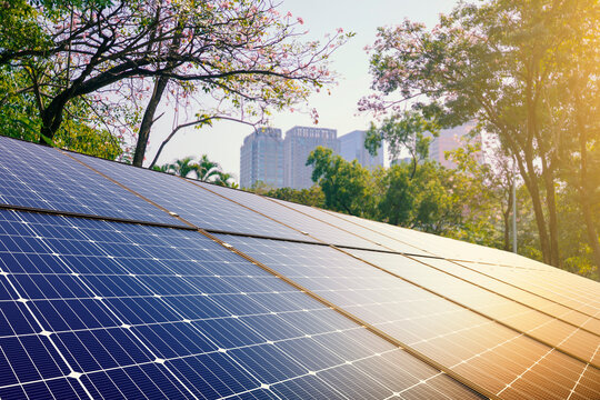 A solar power plant utilizes photovoltaic cell technology on the roof to generate clean renewable energy and electric power from blue sky sunlight for a green environment