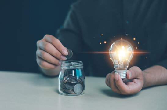 Saving money concept with hand putting coin into jar and glowing light bulb idea. Financial planning, smart investment, budgeting and wealth growth for future security and success.