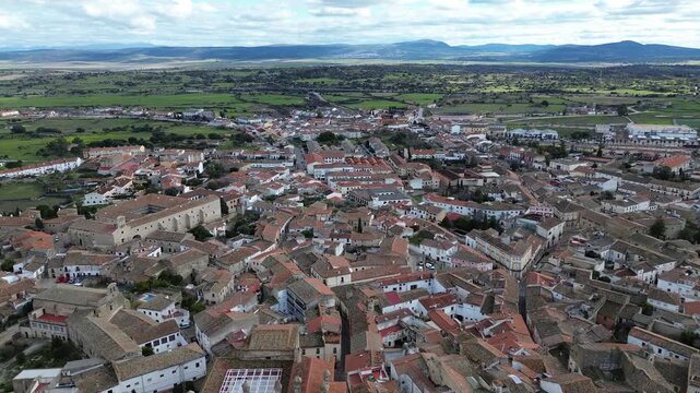 A 4K aerial drone video filmed over the historic center of Trujillo, Extremadura, Spain. The drone flies slowly backward, revealing the old town and the iconic Plaza Mayor, showcasing the medieval