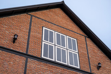 A modern brick building, with window and wall lamps. with blue sky on the background