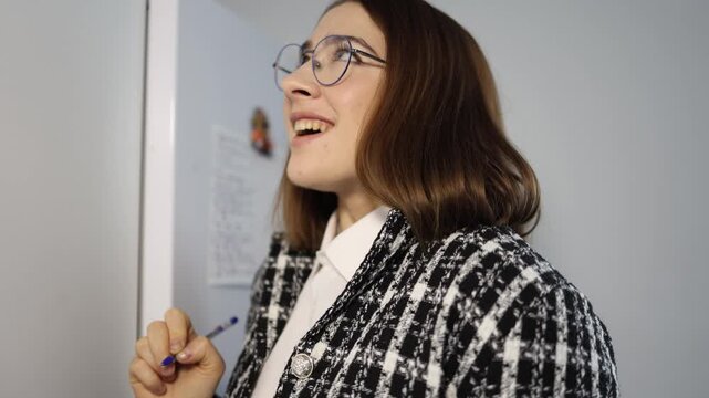 Woman creates a detailed plan on a fridge board focusing on organizing her daily tasks and checking priorities while updating the handwritten list in a calm home setting