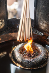 Burning candle flame with incense, in the Buddhist temple