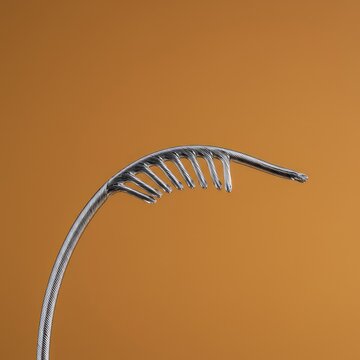 Highly flexible alloy wire bent sharply against a neutral background, illustrating shape memory and superelastic material characteristics ,structure ,tube ,spring