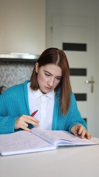 Vertical screen young student studies at her desk trying to focus while an unexpected eye twitch interrupts her concentration creating a tense moment as she struggles to continue writing