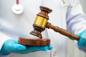 Asian doctor holding court hammer for and crime law justice, forensic medicine.