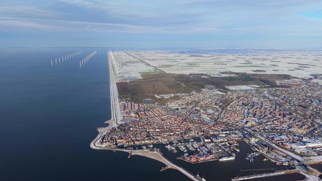 Aerial winter video of Dutch harbor town with offshore wind farm