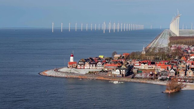 Aerial winter video of Urk harbor with lighthouse and wind turbines