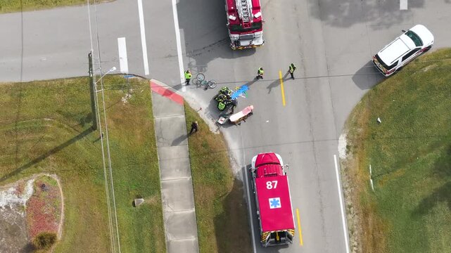 Car accident with pedestrian casualty on highway road in Florida. Emergency services paramedics helping victim of vehicle hit on city street in USA.