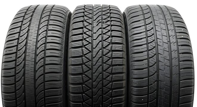 Three black winter tire treads with deep grooves and sipes aligned side by side on white background