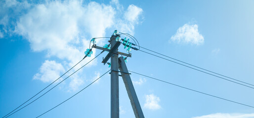 Fototapeta premium Electric cables on electric poles with a blue sky.