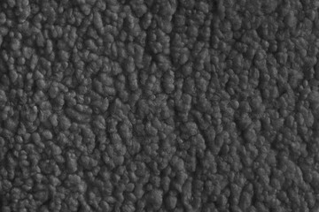 Vibrant black color fabric texture of soft faux fur cloth with fluffy surface, abstract background. Close up, macro of shaggy fabric texture, upholstery material, textile backdrop
