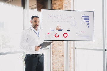 Young handsome businessman presents data and charts in a modern loft office setting