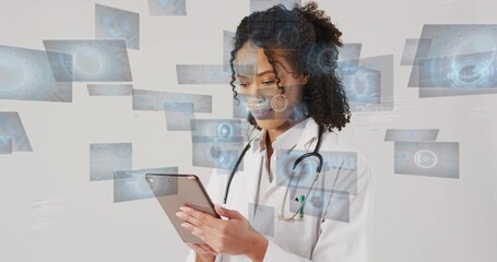 Holding tablet, physician reviewing digital panels at clinic, wearing lab coat and stethoscope