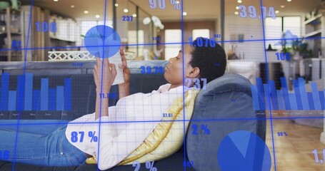 Woman reclining at home in jeans, holding phone on couch with yellow pillow, blue overlays