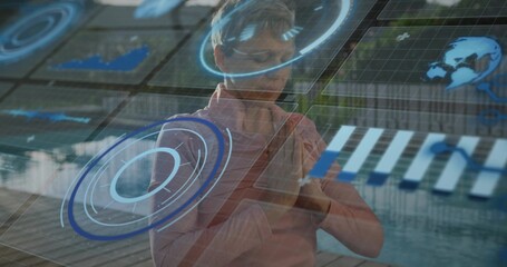 Manipulating mature woman wearing pink shirt adjusting AR holographic UI at atrium, with charts