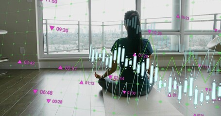 Meditating Asian woman on yoga mat by windows in studio, wearing dark activewear, showing AR charts