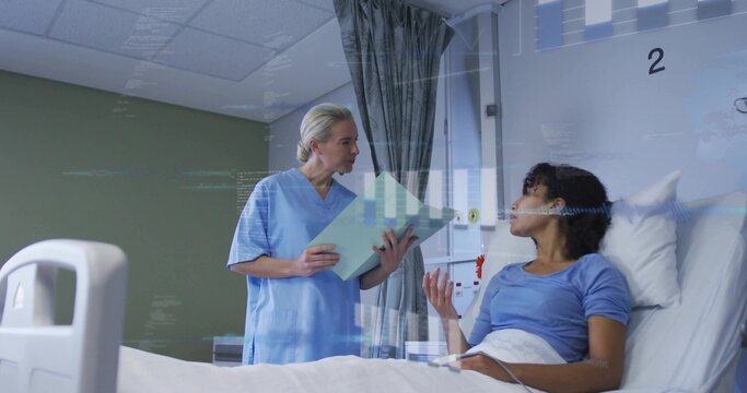 Holding patient-folder, nurse in scrubs standing by hospital bed, patient sitting in blue-top