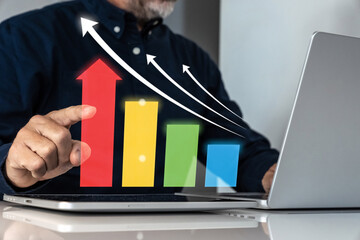 Businessman analyzing financial growth and performance on a futuristic virtual bar chart