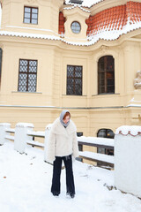 Young woman enjoying winter day near classic European architecture travel lifestyle concept