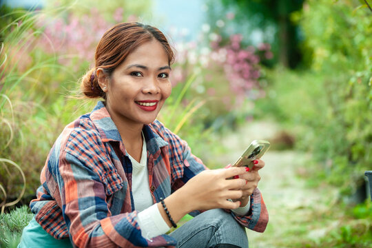 Woman Enjoying Smart phone in Garden