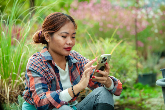 Woman using smart phone in a garden