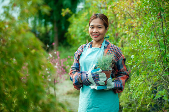 Woman gardening with potted plant in vibrant garden
