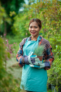 Woman gardening with potted plant in vibrant garden