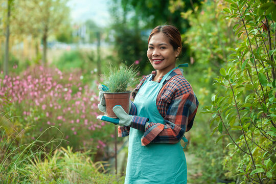 Woman gardening with potted plant in vibrant garden