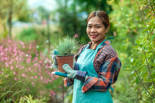 Woman gardening with potted plant in vibrant garden
