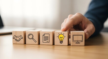 Naklejka premium Person placing wooden block with light bulb on a row of blocks with various symbols