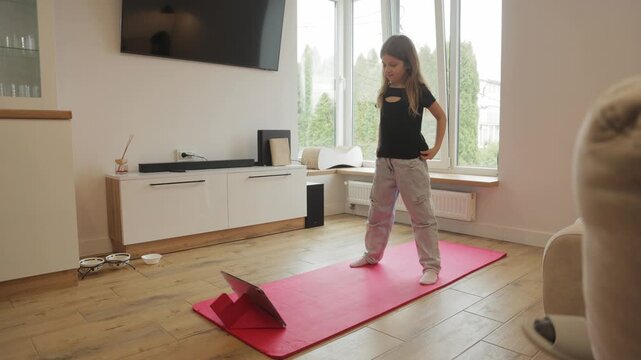 Young Girl Doing Online Fitness Exercises and Stretching at Home