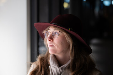 Young Caucasian woman looking at a shop window at night. Close up night portrait, shallow depth of field