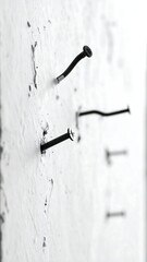 Bent Nails on White Wall - A Study in Imperfection.