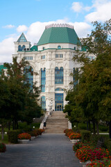 The Astrakhan Opera and Ballet Theater building and a fragment of the theater park in front of the entrance staircase.