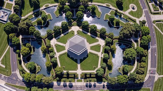 Aerial view of a geometric garden with pathways and water features, showcasing symmetry and greenery. Ideal for a drone video concept.