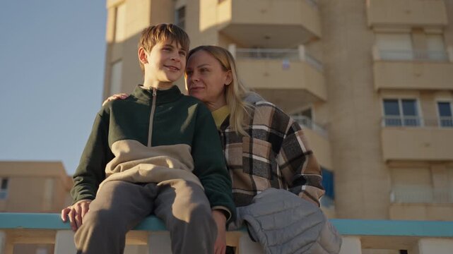 Caring mother supporting her teenage son during a quiet moment uring family walk. Concept of emotional support, mental health, trust and family connection.