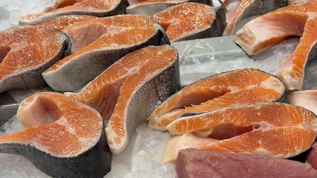 Fresh Salmon Steaks Piled For Wholesale Display, Repeating Orange Cross Sections On Chilled Ice, Busy Supply Signage Vibe Suited For Commercial Buyers, Retail And Catering Supply Contexts.