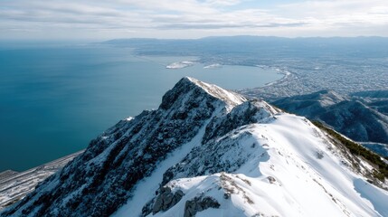 View from snowy rocks in winter showing forest and distant sea during sunrise with cloudy sky above in a natural landscape