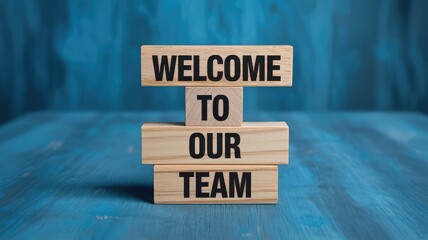 Wooden blocks stacked neatly spell out the friendly and inviting corporate message welcome to our team signifying new employment opportunities and integration.