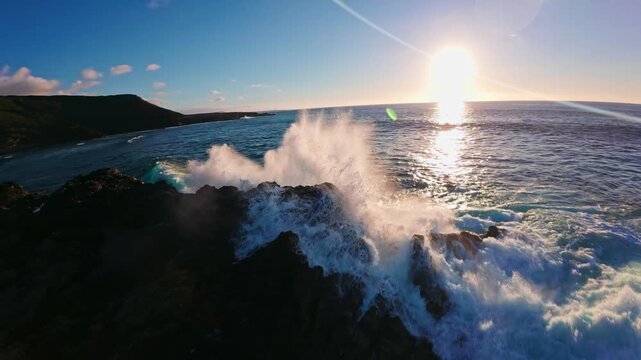 Aerial view shows El Golfo and Los Hervideros on Lanzarote. Turquoise surf crashes on black lava cliffs and sand at golden hour, with spray in inlets and a sweeping bay.