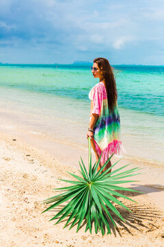 Beautiful lady in a swimsuit and colorful parasol against the background of the sea, on a tropical island, walk on the coast, sitting on a hammock, summer mood