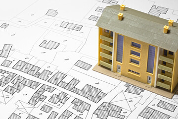 Land plot management - real estate concept with a vacant land for building construction, imaginary General Urban Plan with indications of urban destinations and condominium residential building