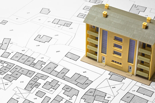 Land plot management - real estate concept with a vacant land for building construction, imaginary General Urban Plan with indications of urban destinations and condominium residential building